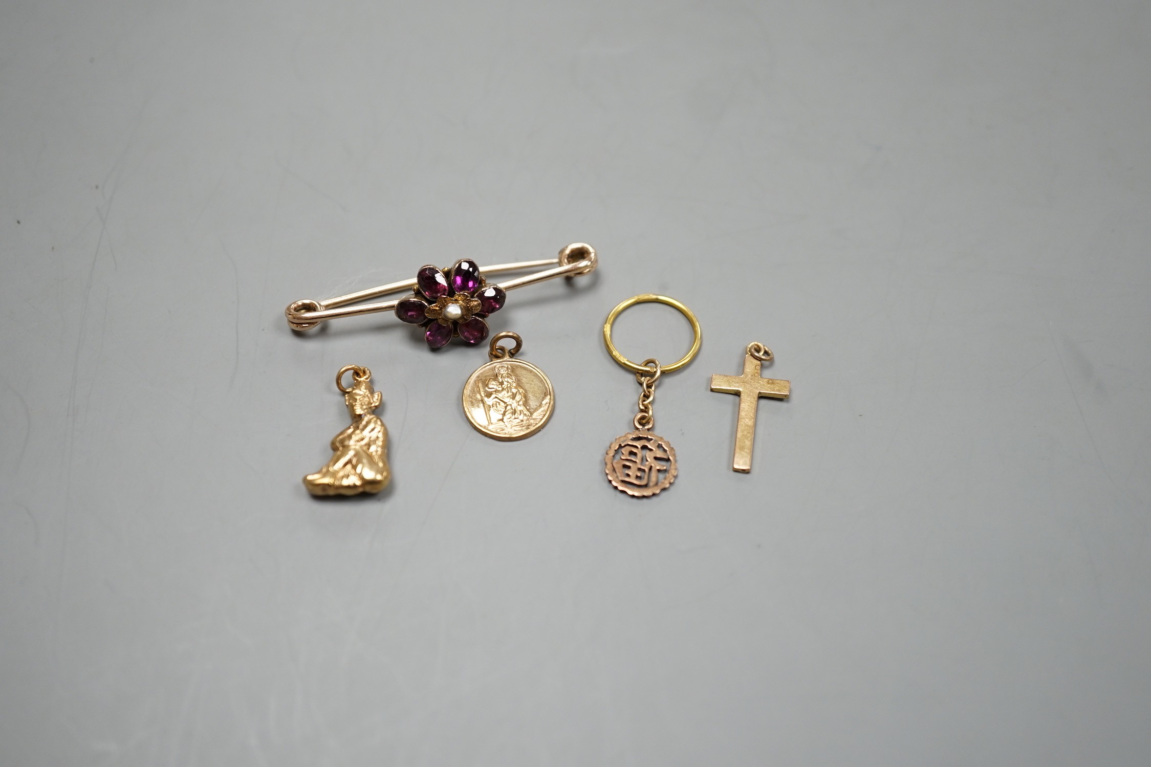 An early 20th century yellow metal, garnet and seed pearl cluster set bar brooch (converted ring?), 44mm and four assorted charms including three 9ct, gross weight 7 grams.